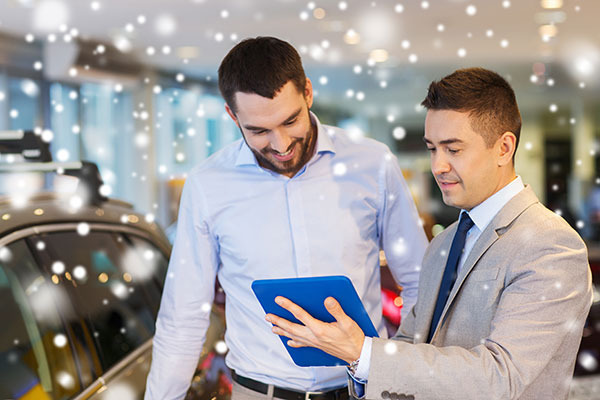 happy man with car dealer in auto show or salon